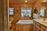 Upper private bathroom with walk-in shower and jetted tub